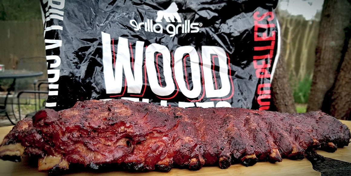 a rack of bbq ribs in front off a bag of wood pellets