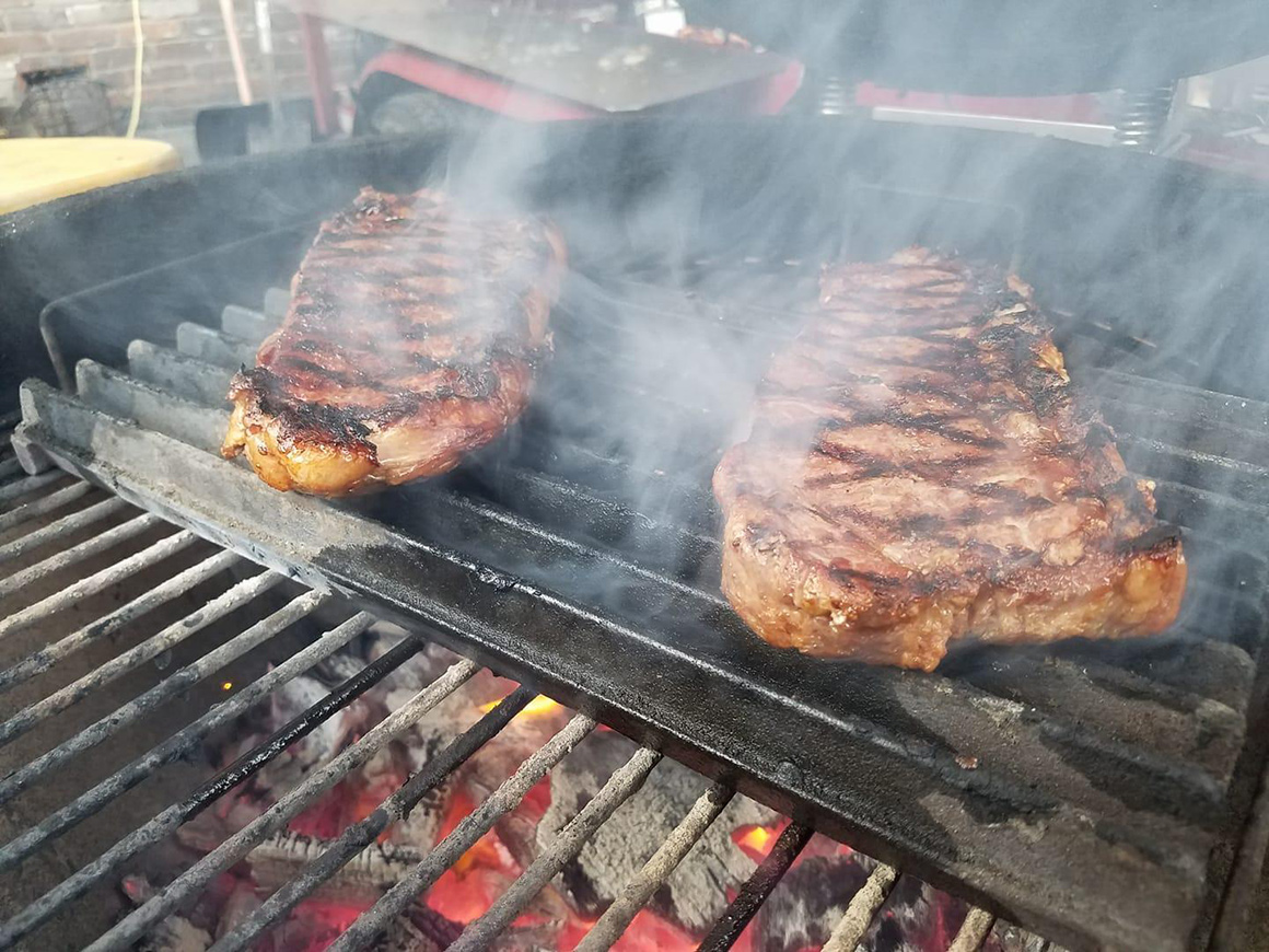 a couple of steaks cooking on a grill pan