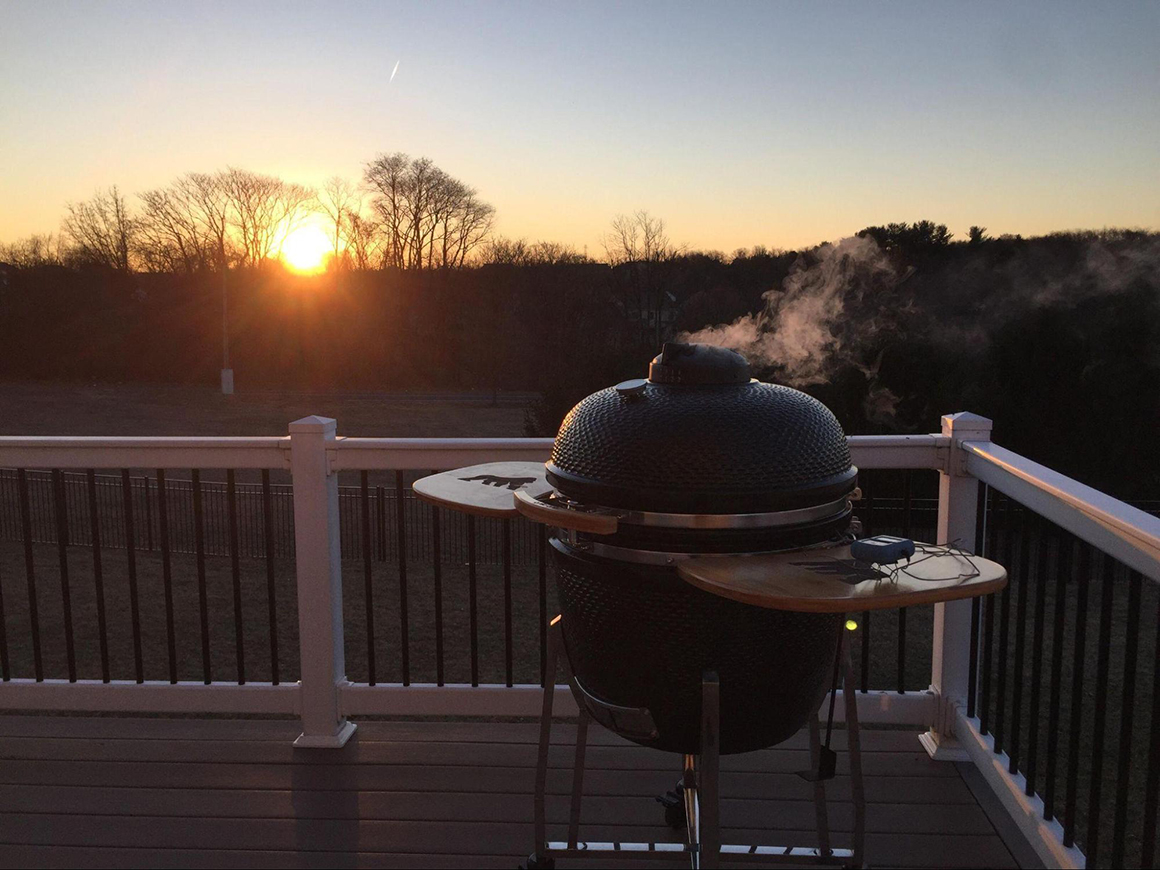 a kong kamado grill being used on a patio with a view of the sunset