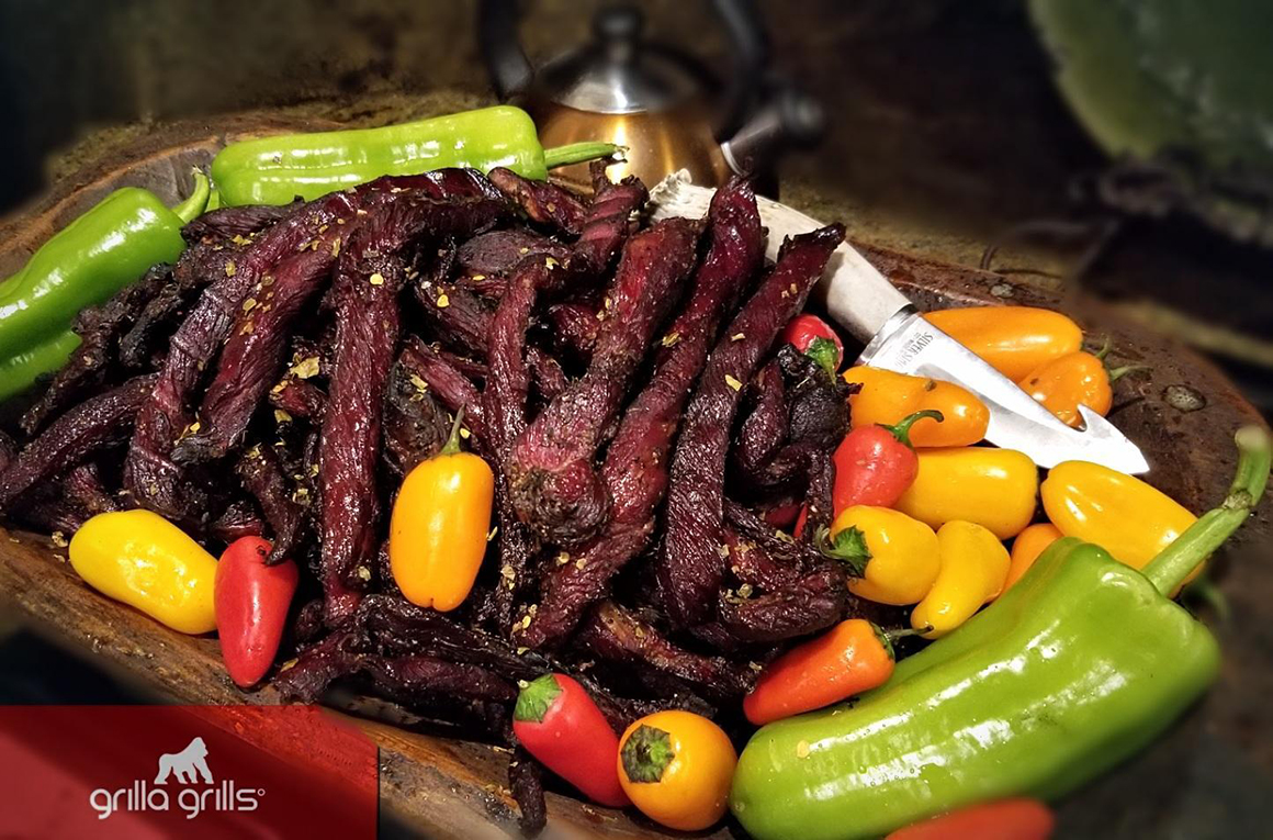 a plate of grilled meat strips and peppers