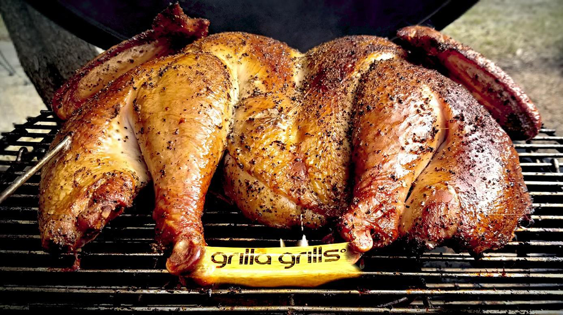 a whole chicken being cooked on a grill