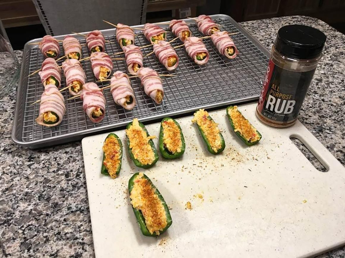 bacon wrapped jalepeno poppers being prepped for a grill